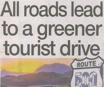 Headline banner featuring “All roads lead to a greener tourist drive” overlaid on an image of a winding Scottish road through green hills, symbolising eco-friendly tourism and sustainable travel.