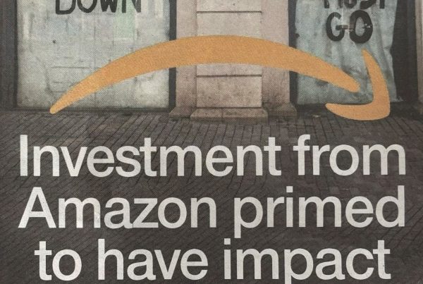 Banner image showing an Amazon logistics hub next to a shuttered high street store, symbolising digital disruption. Bold overlay text reads: “Investment from Amazon primed to have impact on High Streets.”