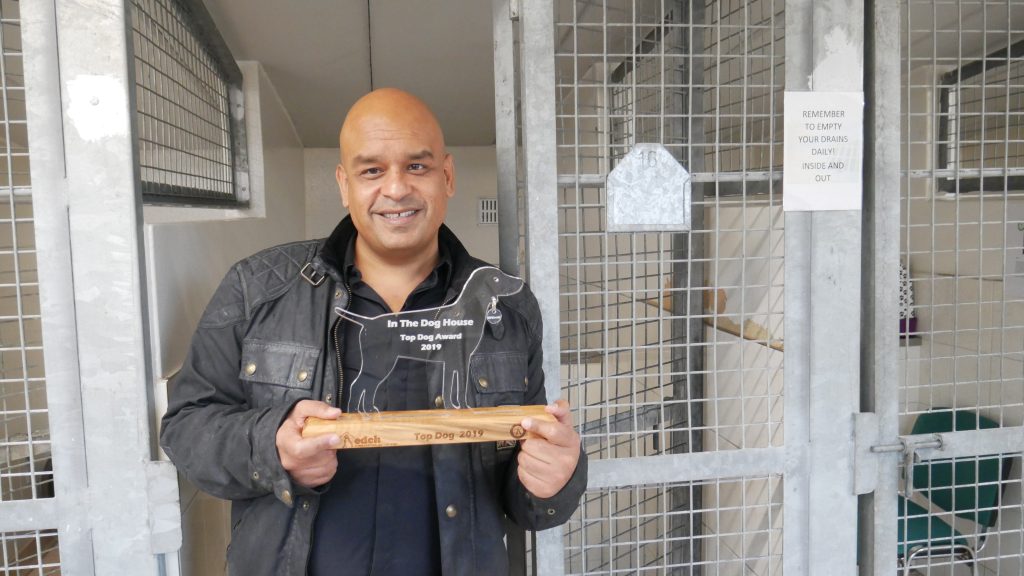 Shaf Rasul being released from the kennels while holding trophy for charity fundraiser at Edinburgh Dog and Cat Home