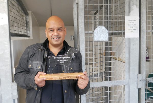 Shaf Rasul being released from the kennels while holding trophy for charity fundraiser at Edinburgh Dog and Cat Home