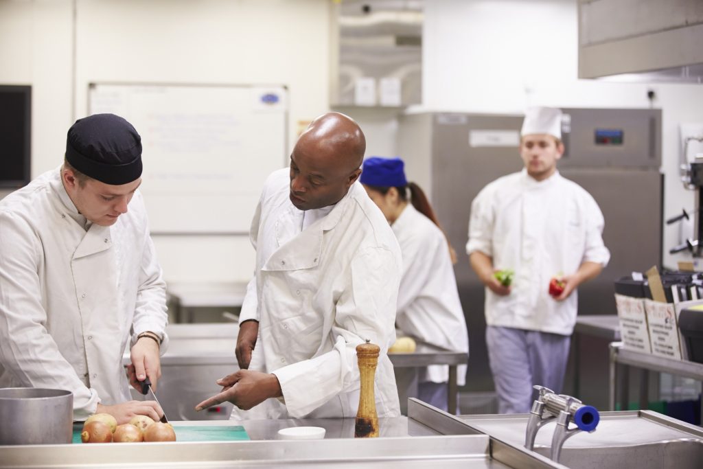 Two chefs working in a professional kitchen, illustrating the concept behind Crowd Kitchens