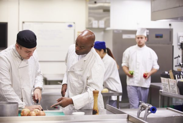 Two chefs working in a professional kitchen, illustrating the concept behind Crowd Kitchens