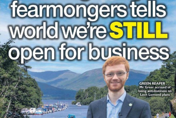 Headline graphic reading “Defeating kneejerk fearmongers tells world we’re STILL open for business” overlaid on a scenic image of Loch Lomond with calm waters, boats, and clear skies, symbolising investment potential.