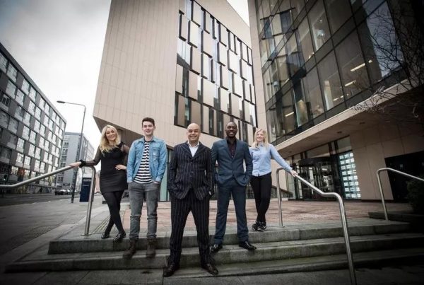 Shaf Rasul standing outside the University of Strathclyde with entrepreneurs from the university