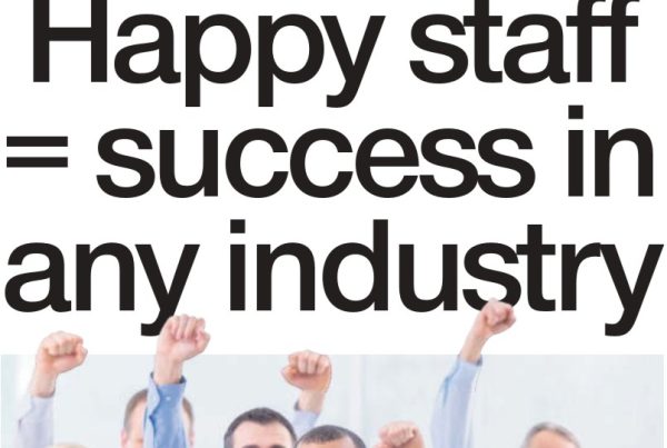 Business team standing in a modern office, smiling and relaxed, with the headline “Happy staff = success in any industry” boldly overlaid across the top.