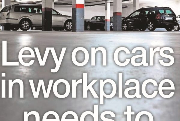 Illustration of a parking lot with a “Workplace Parking Levy” sign, overlaid with the headline text “Levy on Cars in Workplace Needs to Be Parked”.