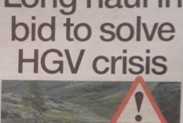 A bold headline reading “Long haul in bid to solve HGV crisis” with a photo backdrop of a supermarket with empty shelves and an HGV truck parked in the background.