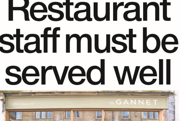 Hospitality workers smiling at a team event outdoors, with the headline “Restaurant staff must be served well” overlaid across a warm autumnal background