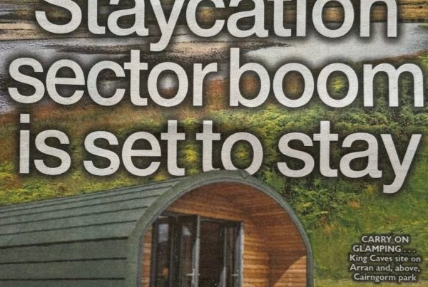 A scenic image of a lochside glamping site with hot tubs, log cabins, and Scottish hills in the background. Overlaid headline reads: “Staycation sector boom is set to stay”.