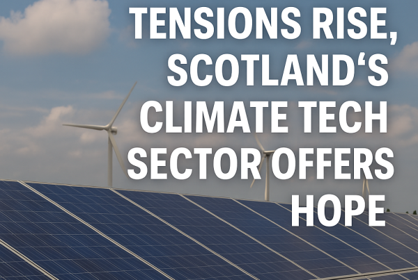 A field of solar panels under a partly cloudy sky with wind turbines in the background. Bold white text overlays the image, reading: "As Energy Tensions Rise, Scotland’s Climate Tech Sector Offers Hope."