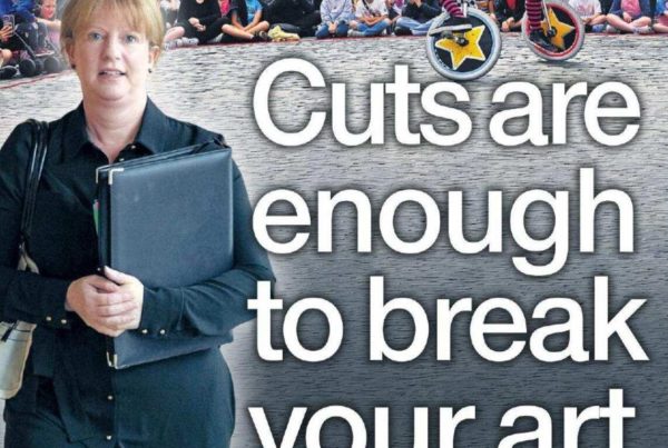 Banner showing a dramatic spotlight on a stage with an empty chair and a broken paintbrush beside it, titled “Cuts are enough to break your art”.