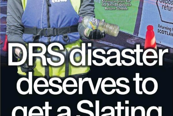 Shaf Rasul in front of a cluttered desk with broken recycling bins and delayed signage marked “DRS 2027,” overlaid with headline: “DRS disaster deserve to get a Slating – 25 May 2024”.