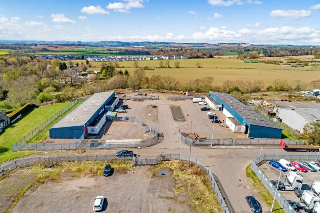 Drone aerial view of the industrial estate on Nobel Road, Wester Gourdie Industrial Estate, Dundee, showing Blocks 11 and 12 and surrounding yard space.
